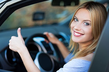 Smiling Young Woman Sitting in a Car